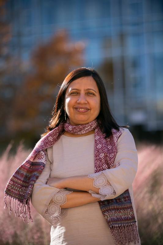 Image of Dr. Aesha John, an associate professor of social work, posing outside