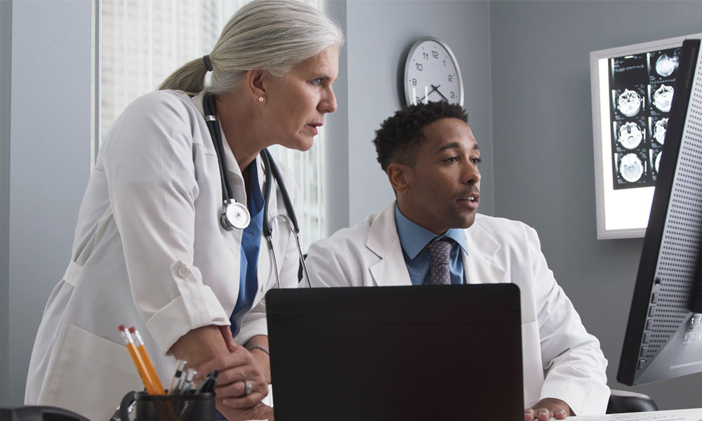 PA professionals at desk evaluating a computer file