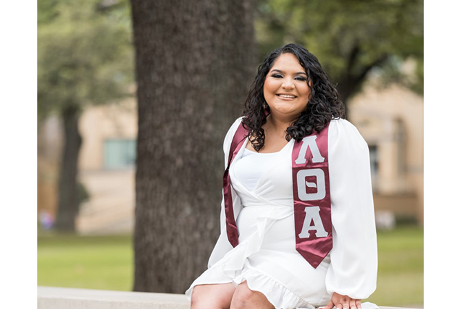 Elena Olalde senior picture on the TCU sign