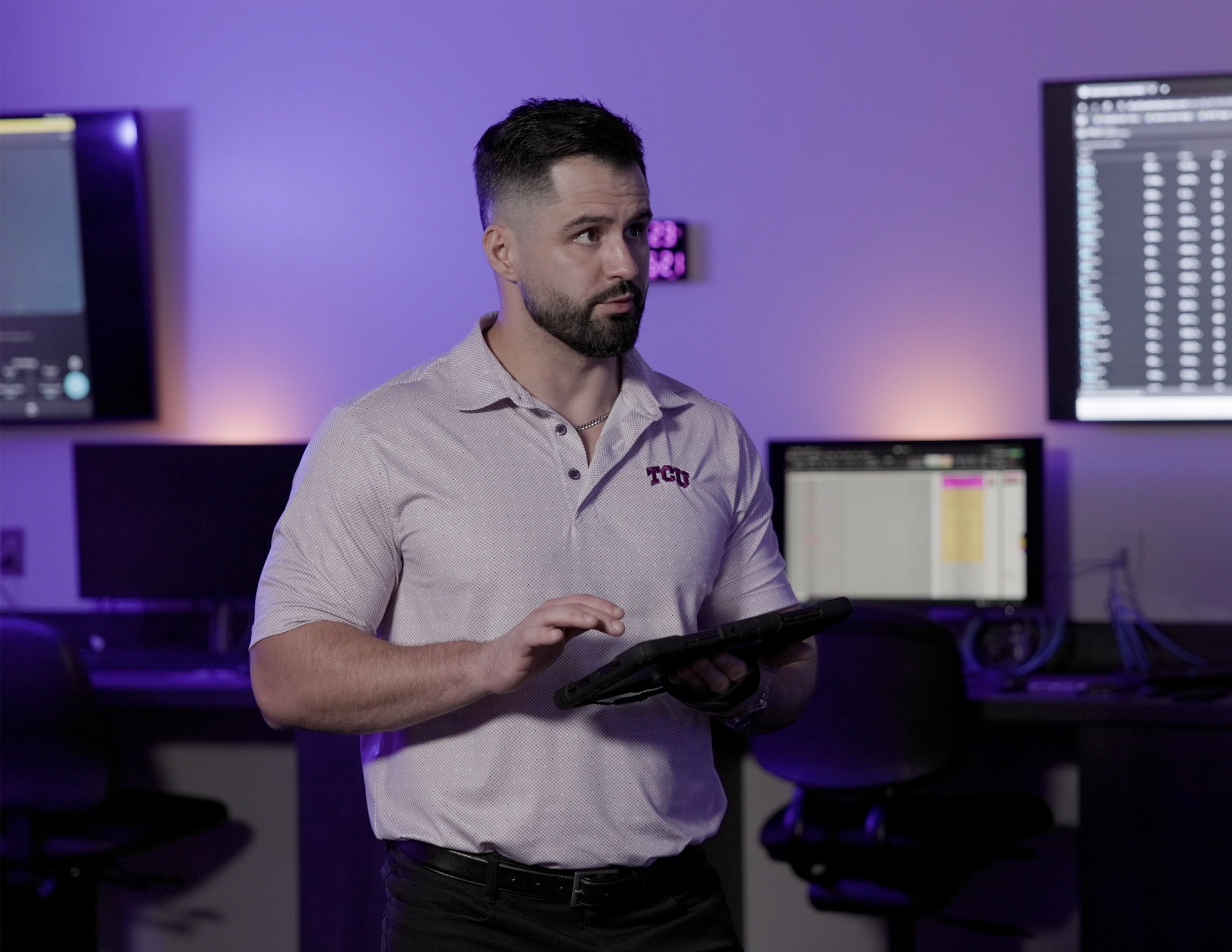 Dr. Austin Graybeal, assistant professor in kinesiology, holding a tablet and standing in the SHAPE Lab.